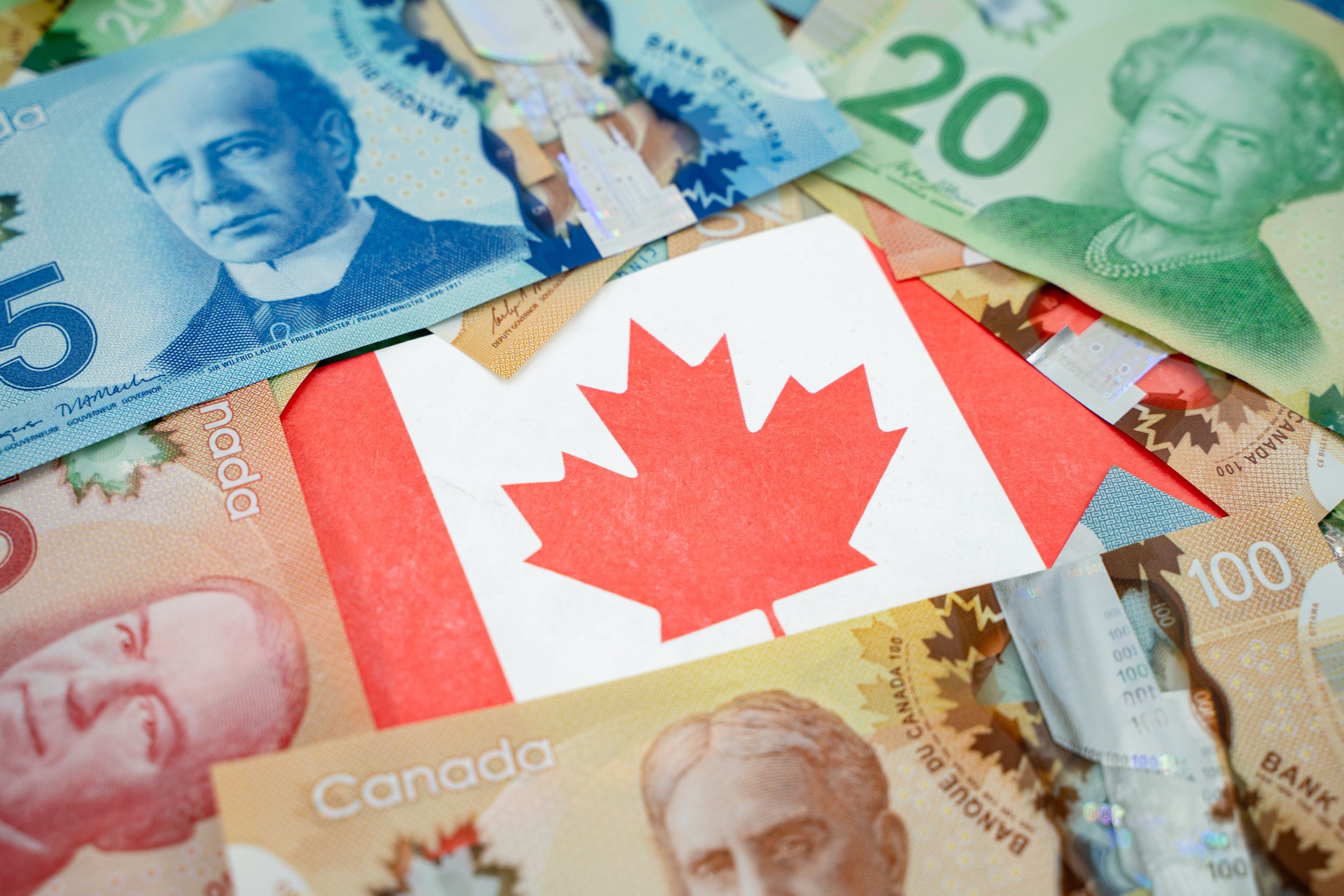 Close up of Canadian flag on dollar banknotes.